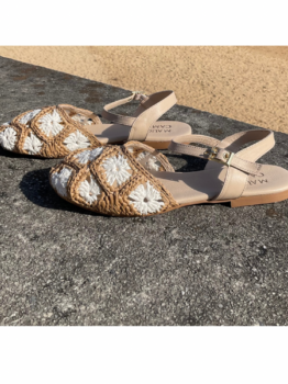 Sandalias planas de mujer con diseño de ganchillo o rafia trenzada en tonos beige y blanco, con tira ajustable al tobillo de cuero color nude